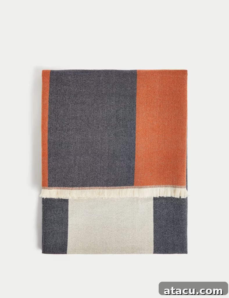 Close-up of a brushed woven geometric throw, highlighting its intricate pattern, rich texture, and inviting softness.