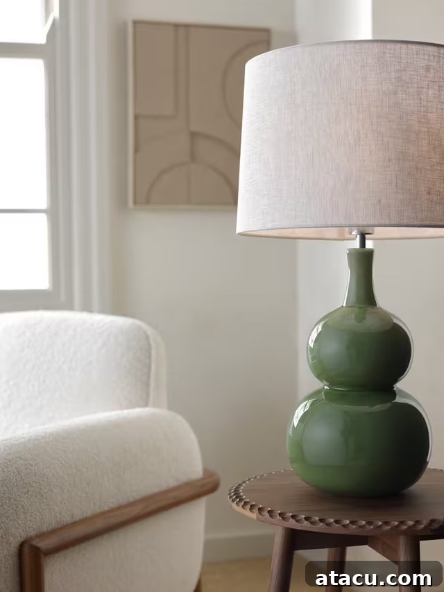 A chic living room corner showcasing a green ceramic sculptural table lamp on a side table next to a comfortable white boucle armchair, creating an inviting ambiance.
