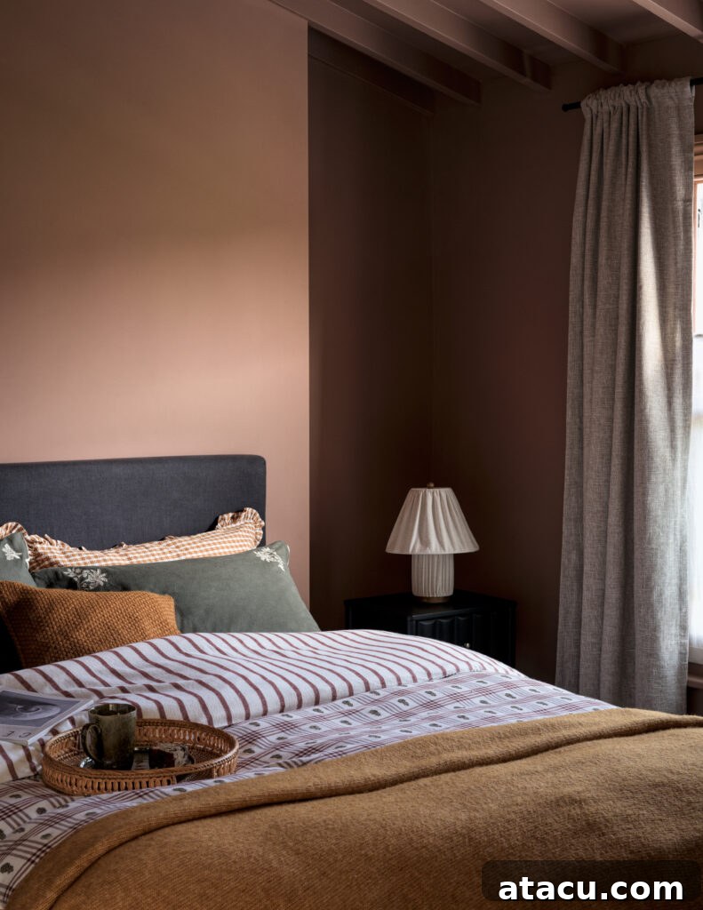 Earth-toned bedroom with layered bedding, dark headboard, and soft ambient lighting.