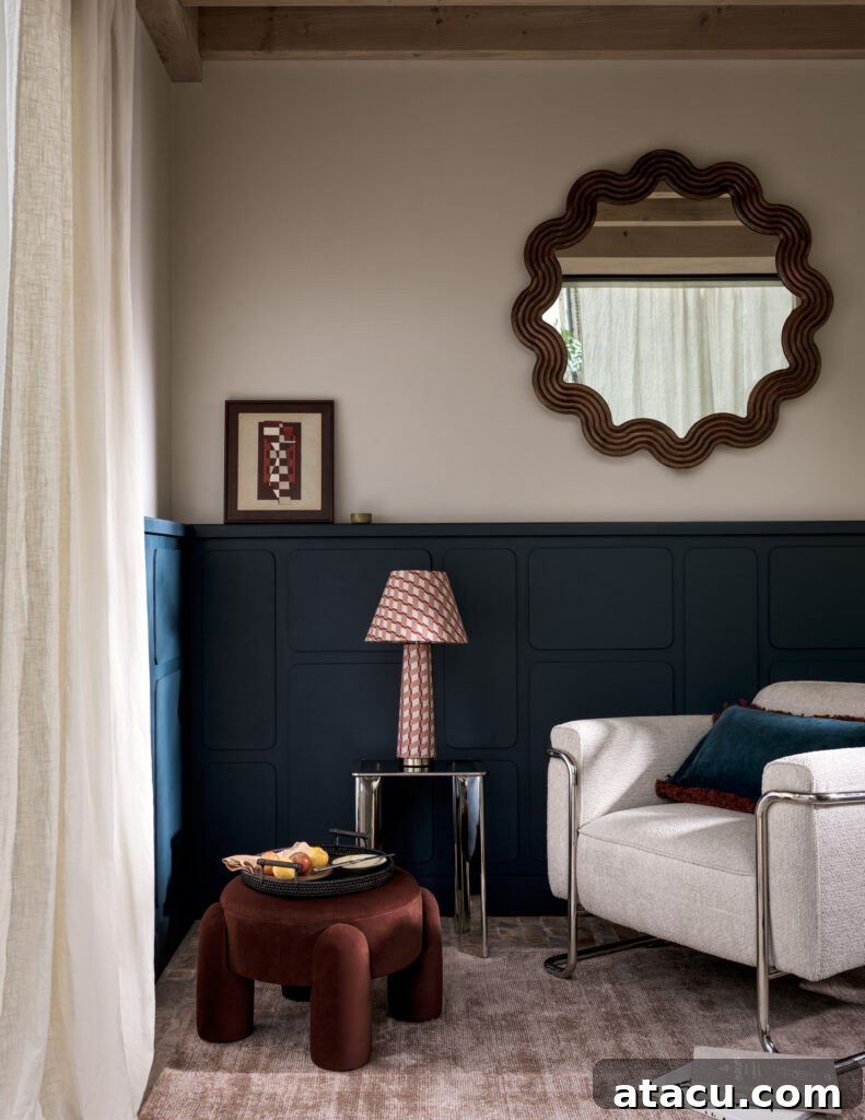 Neutral sitting area with boucle armchair, sculptural ottoman, and scalloped mirror.