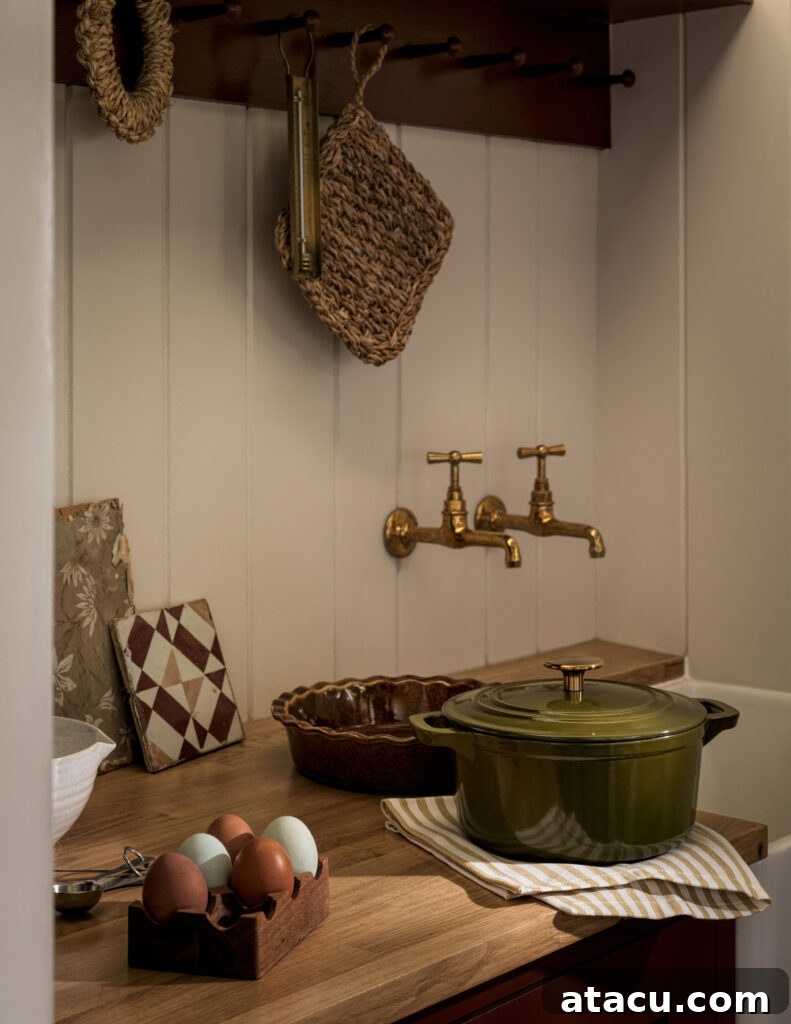 Farmhouse-style kitchen corner with brass taps, olive Dutch oven, and natural textures.