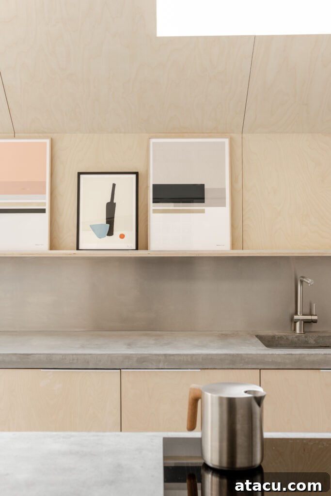 A modern minimalist kitchen featuring a composition of soft wood tones, a sleek concrete surface, and a carefully arranged abstract artwork on a backsplash shelf, creating a calm and inviting aesthetic.