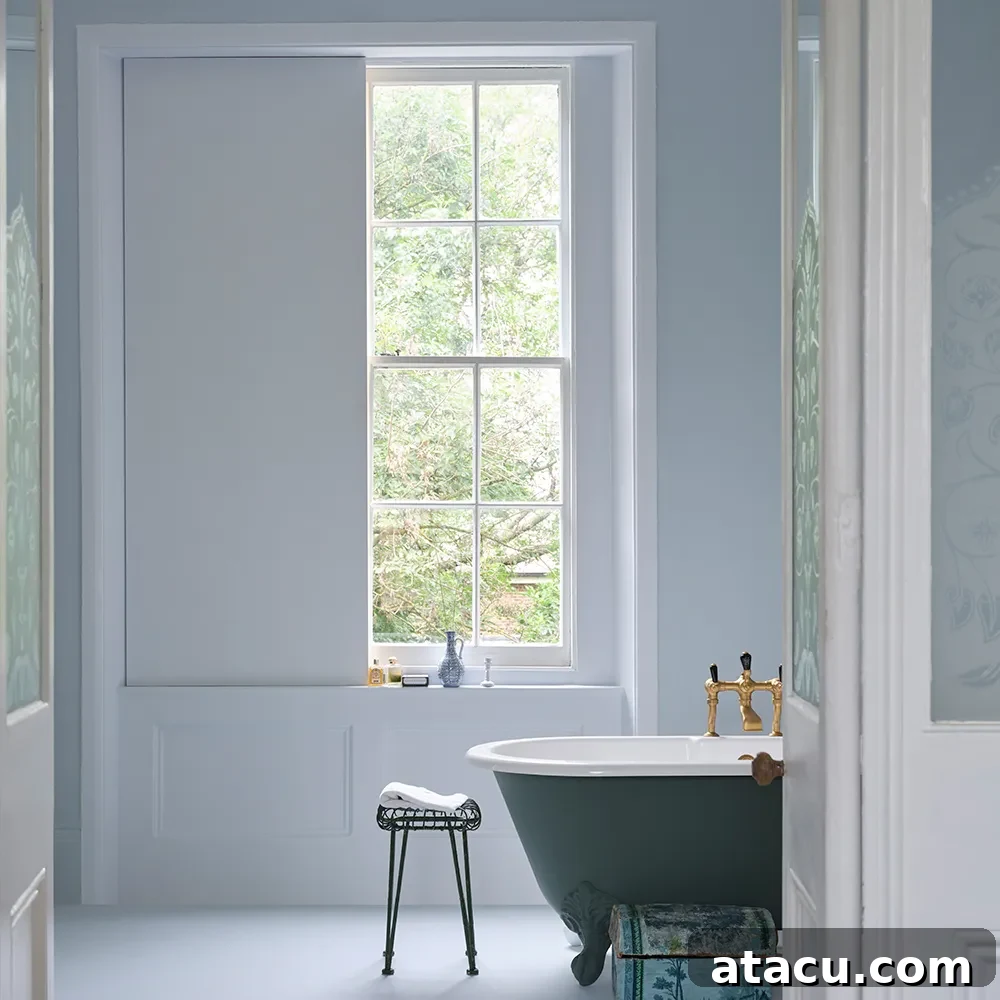 Bathroom featuring a Farrow & Ball 'Sizing' painted wall with a freestanding dark green bathtub.