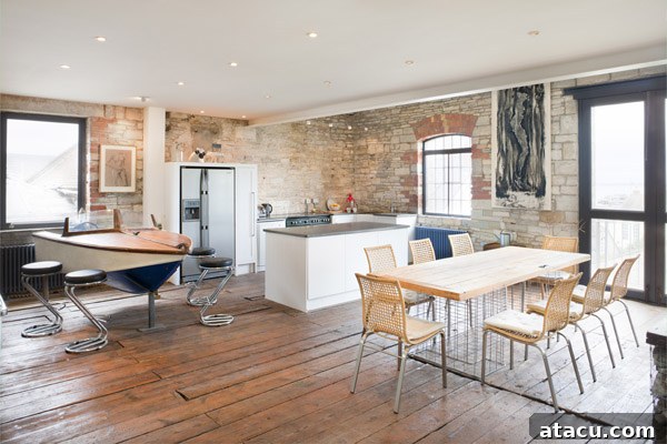 Living room with a hammock hanging from an architectural salvage crane, showcasing Purbeck stone walls.