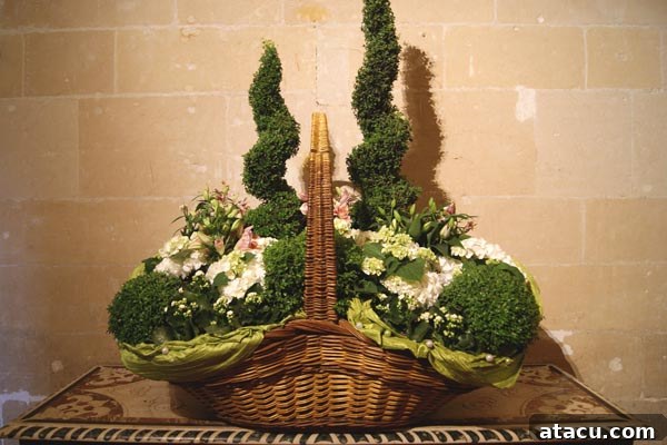 An elaborate floral arrangement featuring delphiniums and other fresh flowers in a stately room at Chenonceau.