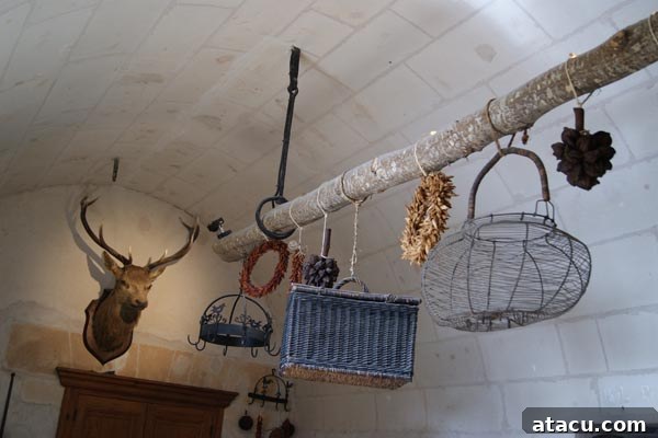 A historical kitchen interior featuring drying racks with garlands, wire, and wicker baskets, exuding rustic charm.