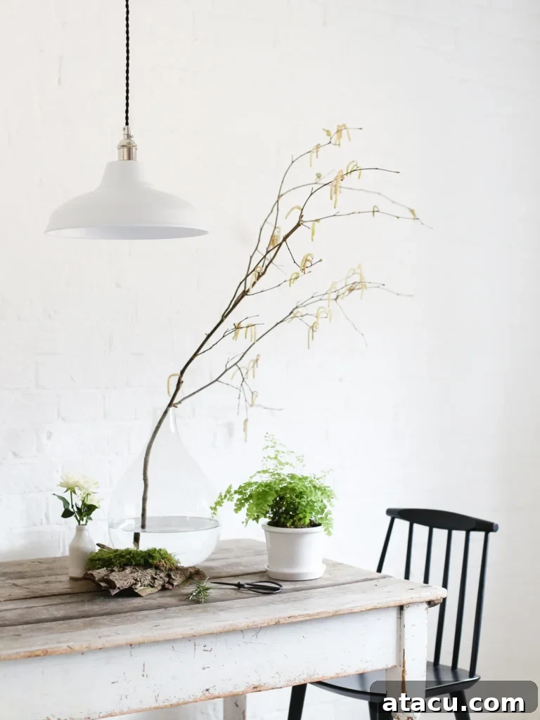 A beautifully arranged bouquet of fresh white and green flowers in an elegant clear glass vase, sitting on a light wooden surface.