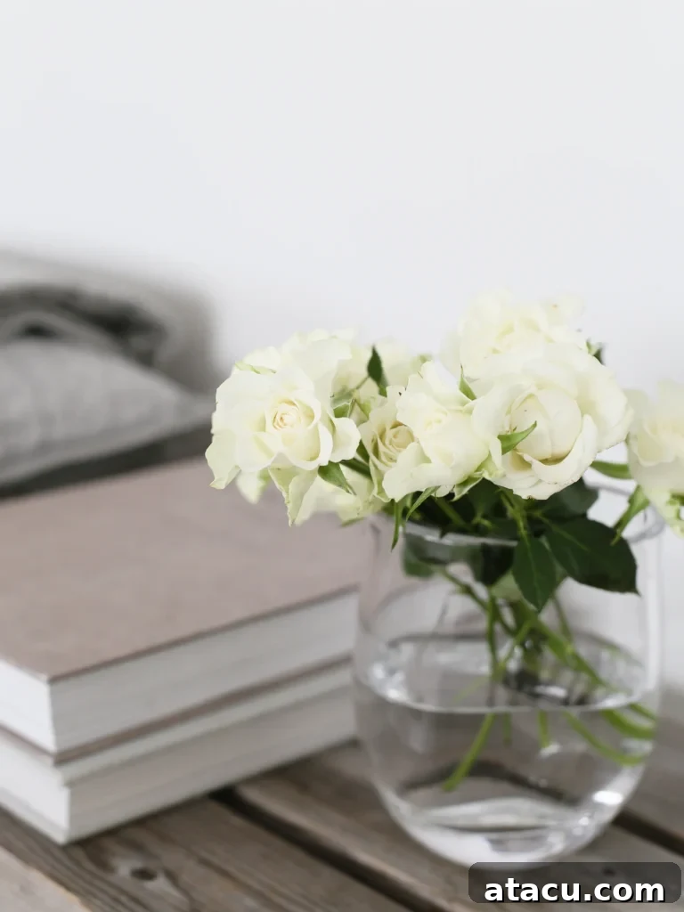 A small, clear glass posy vase holding a cheerful arrangement of small, colorful garden flowers.