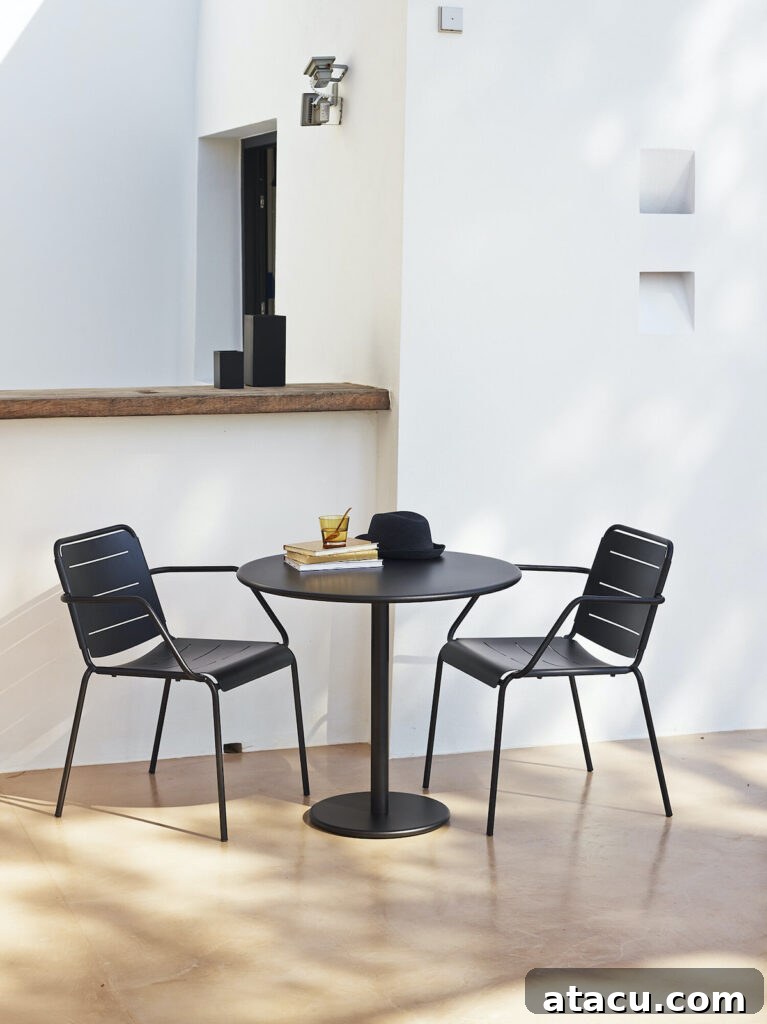 Upgrade Your Outdoors: 10 Best Dining Sets for 2024 9 A stylish black metal outdoor dining table and chairs, showcasing a modern, industrial aesthetic suitable for contemporary spaces.