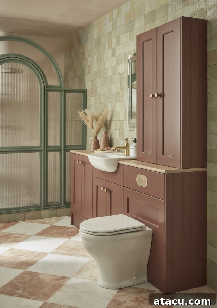 Bathroom featuring the Burford Back to the Wall WC Unit in Terra, with warm terracotta cabinetry, brass fixtures, green arched shower screen, and natural stone tiled walls and floors.