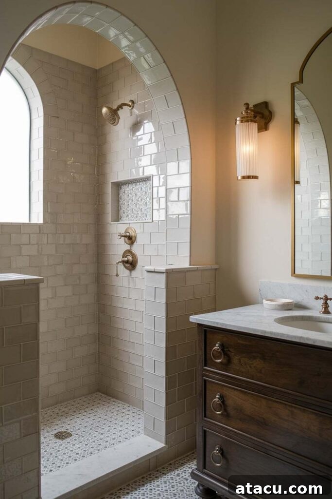 A Spanish Revival bathroom with an arched glass shower, beige zellige tiles, a patterned mosaic floor, and brushed brass fixtures. A dark wood vanity with a marble countertop adds warmth and elegance.